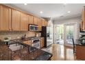 Well-lit kitchen with stainless steel appliances, granite countertops, and wood cabinets at 2728 Wander Ln, Alpharetta, GA 30022