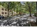 Tree lined street with parked cars near multi-story townhomes at 2728 Wander Ln, Alpharetta, GA 30022