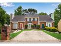 Traditional brick townhouse with mature trees, driveway, and manicured lawn at 1368 Poplar Pointe Se, Smyrna, GA 30082