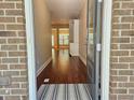 Inviting entryway featuring hardwood floors, a white built-in cabinet, and a view into the adjacent living spaces at 2141 Spikerush Way, Buford, GA 30519