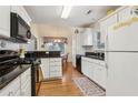 Bright kitchen featuring white cabinets, black countertops, hardwood floors, and modern appliances at 33 Evans Pt, Dallas, GA 30157