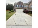 Charming brick home featuring a concrete driveway and landscaped front yard at 5850 Shiloh Woods Dr, Cumming, GA 30040