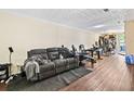 Basement with a gray reclining sofa, wood-look flooring, and plenty of space for activities at 105 North River Dr # A, Atlanta, GA 30350