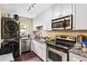 Modern kitchen featuring stainless steel appliances, granite counters, and sleek white cabinetry at 105 North River Dr # A, Atlanta, GA 30350
