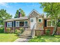 Charming brick home featuring a stone accent entrance, well-manicured lawn, and mature trees under a bright, sunny sky at 1544 Brewer Sw Blvd, Atlanta, GA 30310