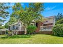 Charming brick home featuring a stone accent entrance, well-manicured lawn, and mature trees under a bright, sunny sky at 1544 Brewer Sw Blvd, Atlanta, GA 30310
