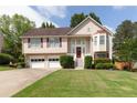 Charming two-story home with a well-manicured lawn, attached garage, and a welcoming front porch at 2577 Abbotts Glen Nw Dr, Acworth, GA 30101