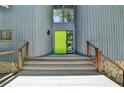 Front entrance with stairs and metal railings leading up to a modern home with a green front door at 945 Tiber Cir, Alpharetta, GA 30022