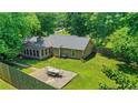 Aerial view of the backyard with a patio set, surrounded by lush greenery and a wooden fence at 1605 Saddlecreek Rd, Auburn, GA 30011