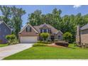 Beautiful brick home with a pristine lawn, mature trees, and an attached two-car garage at 1668 Macy Ln, Lawrenceville, GA 30043