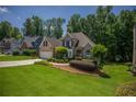 Attractive brick facade, lush green lawn, and mature trees create a welcoming entrance at 1668 Macy Ln, Lawrenceville, GA 30043