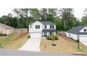 An aerial view of a white two-story home, showcasing its well-manicured lawn and proximity to nature at 3410 Summerpoint Xing, Cumming, GA 30028