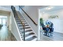 Elegant staircase with dark wood railing and black iron spindles, next to an open office space at 3410 Summerpoint Xing, Cumming, GA 30028