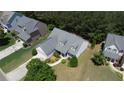 Aerial view of the home with a well-manicured lawn, mature trees, and a two-car garage at 1575 Parkside Village Dr, Cumming, GA 30040