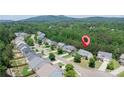 Aerial view of a neighborhood with mature trees and mountain views in the distance at 1575 Parkside Village Dr, Cumming, GA 30040