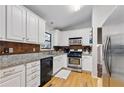 Well-lit kitchen featuring granite countertops, white cabinetry, stainless steel appliances, and modern lighting at 2031 Dennis Pl, Buford, GA 30519