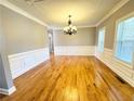 Sunlit living room with hardwood floors, decorative molding, and elegant chandelier lighting at 8967 Midlothian Ct, Winston, GA 30187