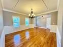 Bright living room with hardwood floors, decorative molding, large windows, and an elegant chandelier at 8967 Midlothian Ct, Winston, GA 30187
