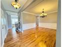 Spacious living room with hardwood floors, decorative molding, and elegant chandelier lighting at 8967 Midlothian Ct, Winston, GA 30187