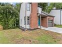 Charming home with a brick chimney and attached garage is framed by lush greenery at 1111 Pin Oak Dr, Tucker, GA 30084