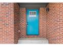 Close-up of a vibrant blue front door with a white-trimmed window inset and brick surround at 1111 Pin Oak Dr, Tucker, GA 30084