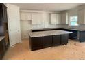 Bright kitchen features granite counters, a center island, and white and dark cabinets at 3292 Mill Forest Dr, Conyers, GA 30094