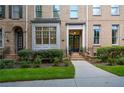 Brick townhome showcasing a welcoming front entrance with landscaped shrubs and a sidewalk at 661 Lockton Pl, Sandy Springs, GA 30342