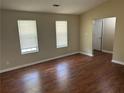 Cozy bedroom with two windows, neutral walls, dark wood-look floors, and a closet door at 6536 Rebecca Lou Ln, Lithonia, GA 30058
