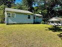 Spacious backyard with lush green grass, mature trees, and a detached garage offering ample parking and storage at 2225 Misty Ln, Smyrna, GA 30080