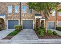 Townhome exterior showcases a private garage, manicured lawn, and inviting front entry at 291 Goodson Nw Way, Atlanta, GA 30309