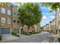 Street view of townhomes that feature sidewalks, landscaping, and garage parking at 291 Goodson Nw Way, Atlanta, GA 30309