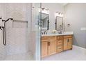 Modern bathroom with a glass enclosed shower, herringbone backsplash, and a double sink vanity with light wood cabinets at 4530 Upland Court, Cumming, GA 30040