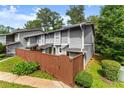 Well-maintained townhome featuring gray siding, wooden privacy fence, and a well-manicured lawn at 5040 Meadow Lane Ne, Marietta, GA 30068