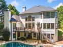 Rear exterior featuring a balcony, pool, large windows, and manicured yard at 414 Dogwood Way, Canton, GA 30114