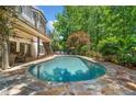 Backyard oasis featuring a pristine pool surrounded by stone and lush greenery for ultimate relaxation at 414 Dogwood Way, Canton, GA 30114