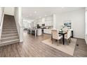 Open floor plan showcasing dining room with wood floors adjacent to a modern kitchen with stainless appliances at 1172 Edwin Ln, Sugar Hill, GA 30518