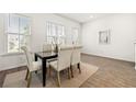 Bright dining room with wood-look flooring, neutral paint, and natural light from large windows at 1172 Edwin Ln, Sugar Hill, GA 30518