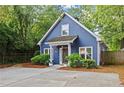 Charming blue house featuring a well-manicured lawn, inviting front porch, and mature landscaping at 2089 College Ne Ave, Atlanta, GA 30317