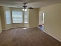 Inviting living room filled with light from bay windows and featuring a ceiling fan at 3827 Micah Ln, Ellenwood, GA 30294