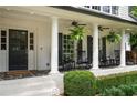 Charming front porch featuring rocking chairs, ferns, and white brick columns at 3894 Land O Lakes Ne Dr, Atlanta, GA 30342