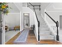 Grand foyer with hardwood floors, staircase with black railing, and neutral wall colors at 7047 Bennington Ln, Cumming, GA 30041