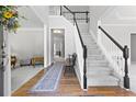 Bright foyer with hardwood floors, staircase, and elegant decor creates a welcoming entrance at 7047 Bennington Ln, Cumming, GA 30041