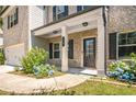 Charming front entrance with brick accents, a black front door, and blooming blue hydrangea bushes at 18 Dorothy Ln, Lawrenceville, GA 30046
