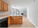 Open kitchen with wooden cabinets, offering a view into the living room with a fireplace at 3283 Sugar Creek Falls Se Ave, Atlanta, GA 30316