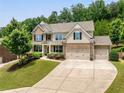 Charming two-story brick home featuring a three-car garage and lush landscaping at 4371 Wigley Preserve Dr, Marietta, GA 30066