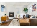 Cozy living room featuring a leather sectional, fireplace, hardwood floors, and natural light at 936 Ormewood Se Ter, Atlanta, GA 30316