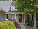 Close-up of home's entry featuring a welcoming front porch with rocking chairs and manicured shrubs at 139 Mountain Vista Blvd, Canton, GA 30115