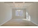 Well-lit dining room featuring coffered ceilings, chandelier, and a large window at 2525 Dixon Pl, Lawrenceville, GA 30045