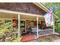 Inviting covered front porch with seating area, red shutters, and a brick facade at 4544 Ridgeview Dr, Powder Springs, GA 30127