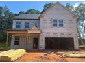New construction two-story home featuring an attached two-car garage and a covered front porch at 5371 Heron Bay Blvd, Locust Grove, GA 30248